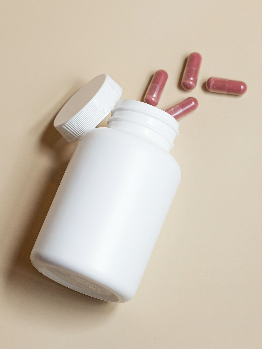 Supplement bottle with capsules on a neutral background