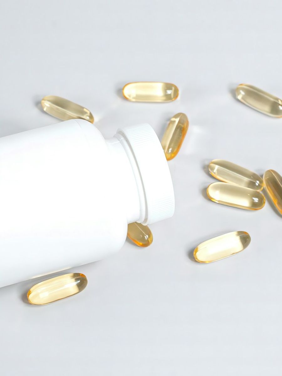Supplement capsules spilling from a bottle